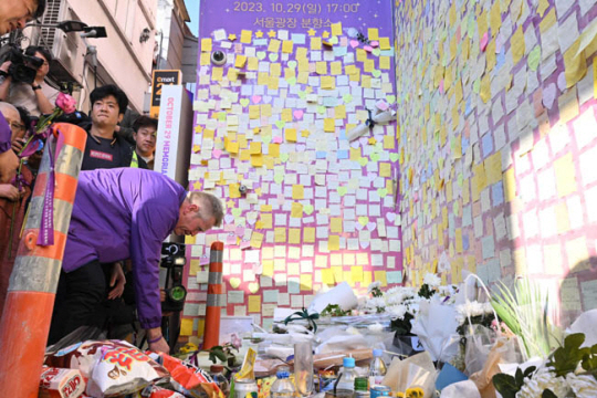 10·29 이태원 참사 1주기를 맞은 29일 오후 서울 용산구 이태원 참사 현장에 마련된 ‘10·29 기억과 안전의 길’의 추모 공간‘에서 유가족이 헌화하고 있다. [공동취재] 연합뉴스
