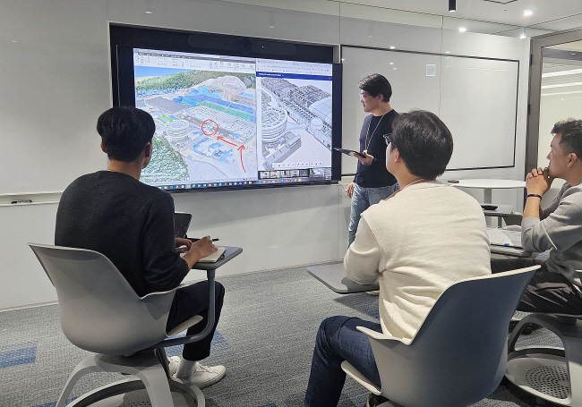 지난 10월 서울 서초구 GS건설 연구·개발센터 ‘명확한’ 회의실에서 빌딩정보모델링팀 관계자들이 인프라 건설현장과 화상회의를 하며 설계 모델을 가다듬고 있다.  GS건설 제공