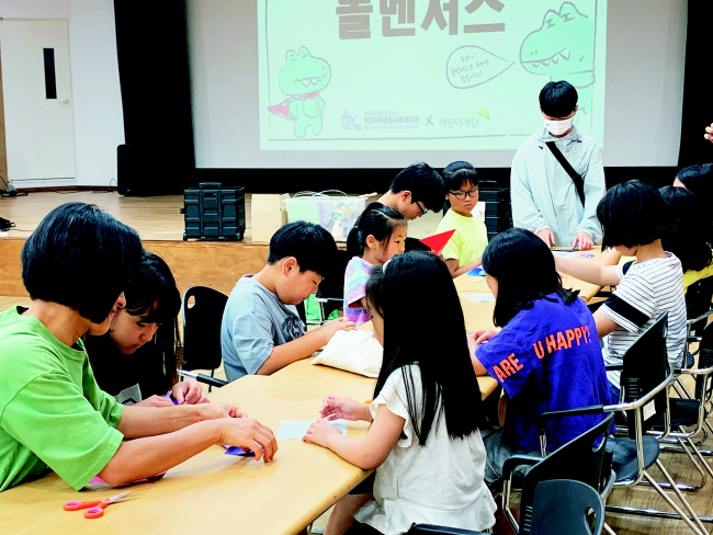 경기 시흥 작은자리종합사회복지관이 구성한 아동권리지킴단 ‘놀벤저스’ 소속 아동들이 지난 7월 15일 가족들과 복지관에서 종이 등을 활용해 놀잇감을 만들고 있다. 초록우산 제공