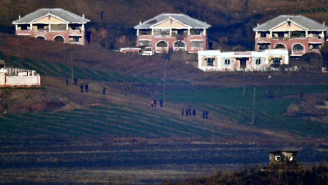 북한의 군사정찰위성 발사가 임박한 21일 새벽 경기 파주 오두산전망대에서 바라본 북한 황해북도 개풍군의 마을 일대 모습. 주민들이 밭 사이로 이동하고 있다. 백동현 기자
