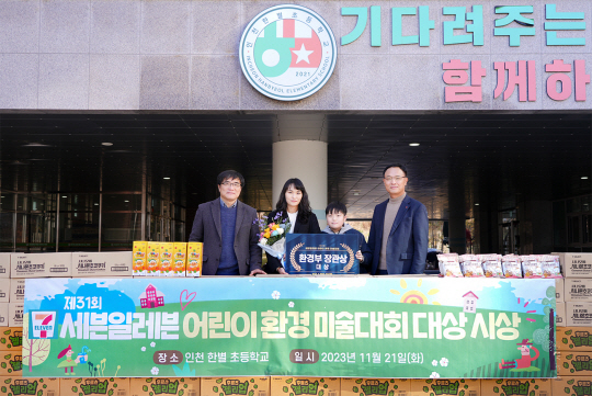 21일 오전 인천 서구 한별초등학교에서 최경호 세븐일레븐 대표이사(오른쪽 첫 번째)와 이유찬 학생(〃두 번째)이 학부모, 학교관계자와 함께 시상식 후 기념촬영을 하고 있다. 세븐일레븐 제공