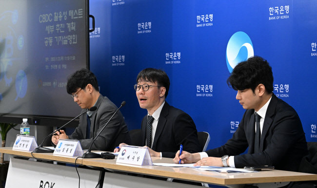 23일 서울 중구 남대문로 한국은행 본관에서 열린 ‘중앙은행 디지털화폐(CBDC) 활용성 테스트 활용사례 및 세부 계획에 대한 기자설명회’에서 김동섭(가운데) 한국은행 디지털화폐기획팀장이 발언하고 있다.   문호남 기자