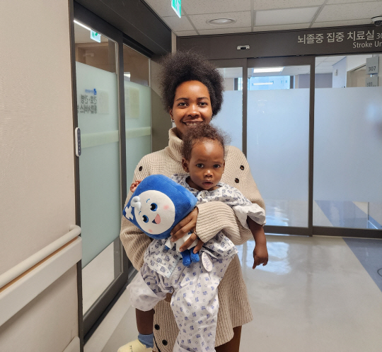 부천세종병원에서 심장 치료를 받고 회복한 우간다 국적 아이작 군과 보호자 레이첼 씨가 기념촬영하고 있다.  부천세종병원 제공