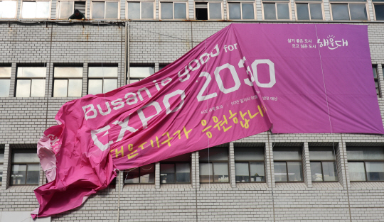 지난 29일 오전 부산 해운대구청사 외벽에 걸려 있던 엑스포 응원 현수막이 철거되고 있다. 연합뉴스