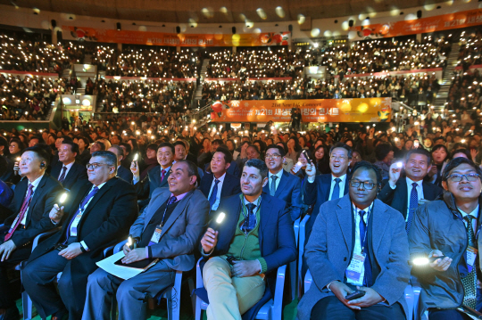 새생명 사랑의 콘서트에 참석한 각국 대사와 외교관들이 플래시를 흔들며 성악가 및 가수들의 무대를 즐기고 있다.