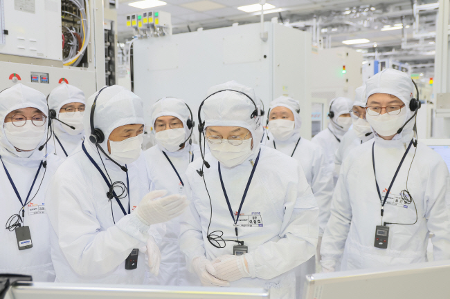 이종호(가운데) 과학기술정보통신부 장관이 11월 28일 반도체산업 규제 개선 현장 점검 차원에서 경기 이천시 SK하이닉스 이천캠퍼스를 방문해 반도체 생산라인을 살펴보면서 관계자의 설명을 듣고 있다.  뉴시스