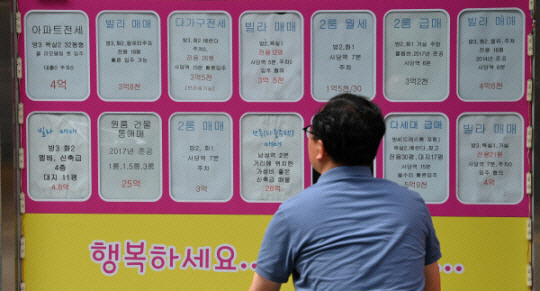 한 서울 시민이 공인중개사 사무소 앞에 붙은 매물 게시물을 살펴보고 있다. 문호남 기자