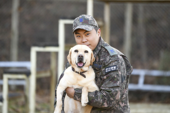 국내 첫 마약탐지 군견인 제20전투비행단 딘딘(4세· 리트리버)과 군견운용요원(핸들러) 김성원 중사가 포즈를 취하고 있다. 공군 제공