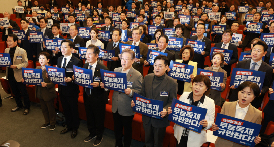 이재명 더불어민주당 대표, 홍익표 원내대표 등 참석의원들이 7일 오전 서울 여의도 국회 도서관에서 열린 제2차 중앙위원회의에서 손 피켓을 들고 구호를 외치고 있다. 뉴시스