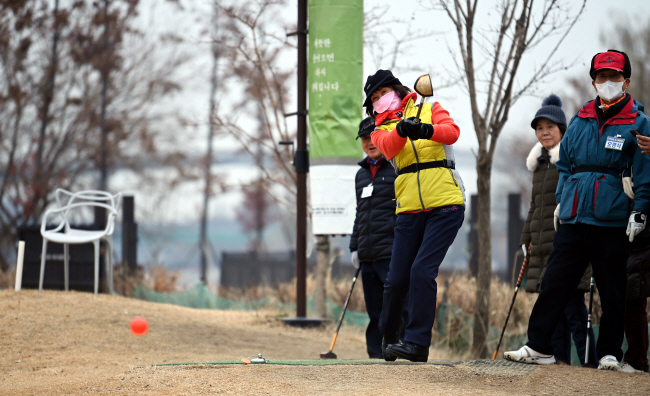 조덕순(68·오른쪽 세 번째) 씨가 지난 6일 서울 영등포구 양평동 양평누리체육공원 파크골프장에서 추운 날씨에도 아랑곳없이 즐겁게 티샷하고 있다.  박윤슬 기자