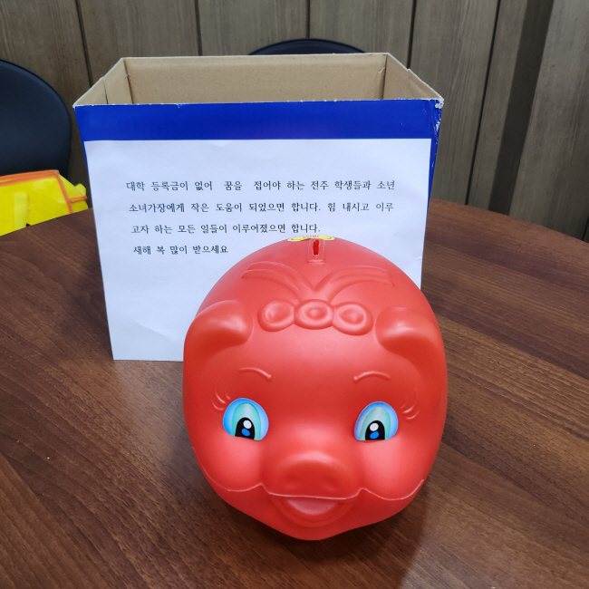 ‘얼굴 없는 천사’가 지난해 전북 전주시 노송동주민센터에 전달한 돼지저금통과 메시지.   HD현대1%나눔재단 제공