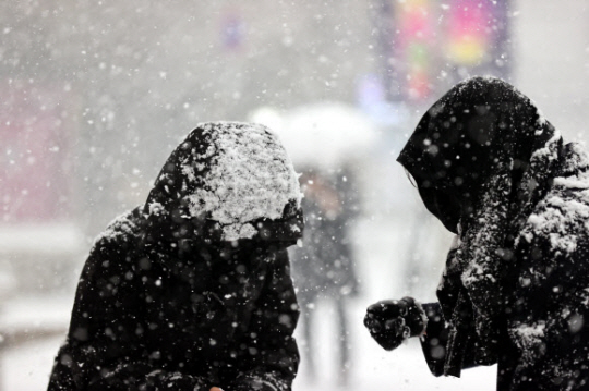 서울 명동에서 시민들이 눈을 맞고 있다. 연합뉴스