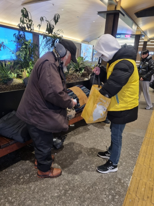 서울시 거리상담반이 서울역지하도에 있는 노숙인에게 물품을 지원하고 있다. 서울시청 제공
