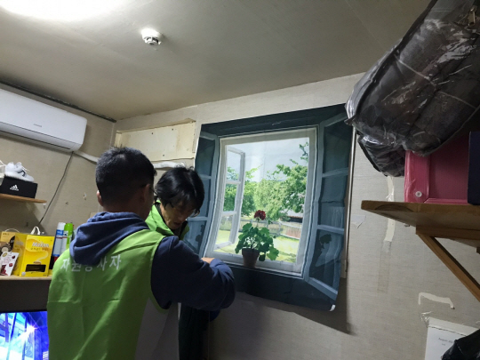 서울시 자원봉사자들이 동자동 쪽방촌에 있는 한 가구를 방문해 한파 대비 방풍커튼을 설치하고 있다. 서울시청 제공