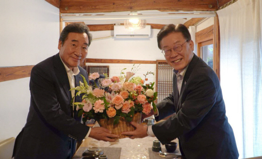 이재명 더불어민주당 대표와 이낙연 전 대표가 지난 7월 28일 서울 모처에서 만찬회동을 하기 전 기념촬영을 하고 있다.  더불어민주당 제공