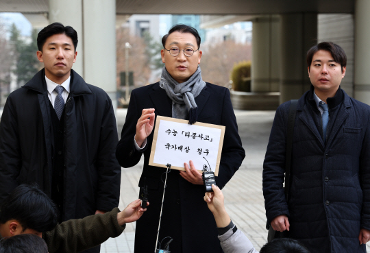 19일 오후 서초구 서울중앙지법에서 법무법인 명진 대표 김우석(가운데) 변호사가 2024년 수능 경동고 타종 사고 국가배상 청구에 앞서 취재진과 인터뷰를 하고 있다. 연합뉴스