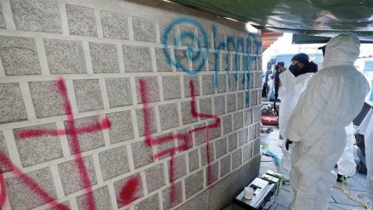 17일 오전 서울 종로구 국립고궁박물관 쪽문 경복궁 담벼락 앞에서 문화재청 관계자들이 전날 누군가가 스프레이로 쓴 낙서 제거 작업을 하고 있다. 연합뉴스(공동취재)