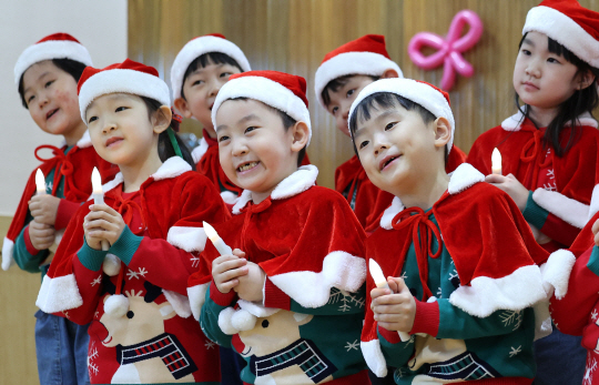 성탄절을 앞둔 21일 대구 달서구 계명문화대학교 부설 어린이집에서 산타 복장을 한 어린이들이 촛불 모양 전구를 들고 캐럴을 부르고 있다.뉴시스
