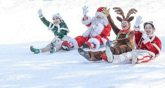 크리스마스이브인 24일 대구 달서구 이월드 눈썰매장에서 산타 분장을 한 직원이 눈썰매를 타고 있다. 연합뉴스