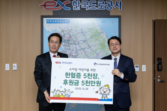 함진규(왼쪽) 한국도로공사 사장이 서신원 한국백혈병어린이재단 사무총장에게 헌혈증 및 치료비를 전달한 후 기념촬영을 하고 있다. (도공 제공)