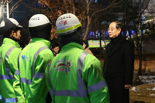 한덕수 국무총리가 1일 새벽 서울 종로구 청진 공원에서 갑진년 첫날 근무에 나선 환경공무원들을 만나 격려하고 있다. 국무총리실 제공