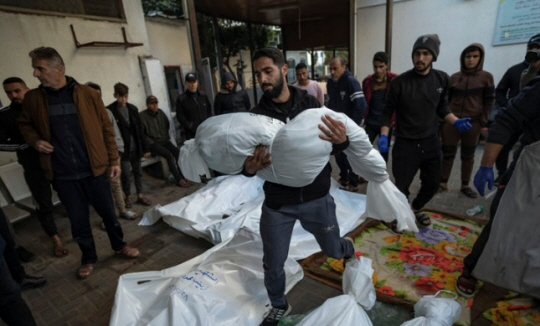 가자지구 남부 라파 시내에서 12월 29일 이스라엘군 폭격으로 사망한 가족의 시신을 운반하는 팔레스타인 남성. 포탄이 빗발치는 가자지구 전투에서 이스라엘군으로 위장 잠입해 무기류를 훔쳐판 이스라엘 30대 남성이 체포되어 재판을 받고 있다고 1월 1일 이스라엘 언론들이 보도했다. AP 뉴시스