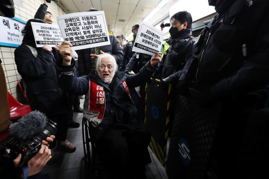 박경석 전국장애인차별철폐연대(전장연) 대표가 2일 오전 서울 종로구 혜화역 승강장에서 열린 출근길 지하철 탑승 시위에서 지하철 탑승을 시도하기 위해 이동하고 있다. 연합뉴스