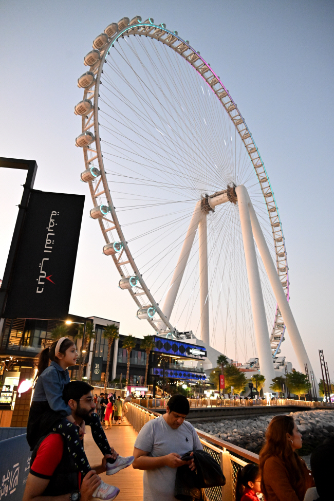 지난해 12월 26일 아랍에미리트(UAE) 두바이의 블루워터스 아일랜드에서 관광객들이 세계 최고 높이 대관람차 ‘아인 두바이’를 배경으로 바다를 바라보고 있다.    문호남 기자지난해 12월 26일 아랍에미리트(UAE) 두바이의 블루워터스 아일랜드에서 관광객들이 세계 최고 높이 대관람차 ‘아인 두바이’를 배경으로 바다를 바라보고 있다.    문호남 기자