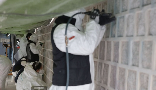 2023년 12월 19일 오후 서울 종로구 경복궁 고궁박물관 방향 담벼락에서 문화재청 관계자들이 스프레이 래커 낙서를 제거하는 작업을 하고 있다. 연합뉴스 자료사진