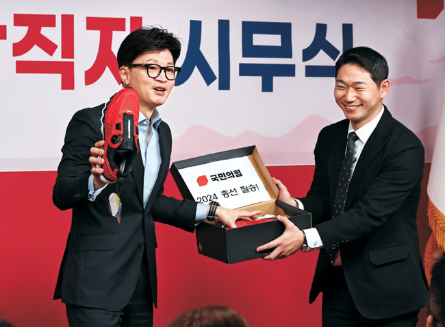 한동훈(왼쪽) 국민의힘 비상대책위원장이 5일 오전 서울 여의도 국민의힘 중앙당사에서 열린 당직자 시무식에 참석해 신입 당직자로부터 운동화를 선물받고 있다.  박윤슬 기자