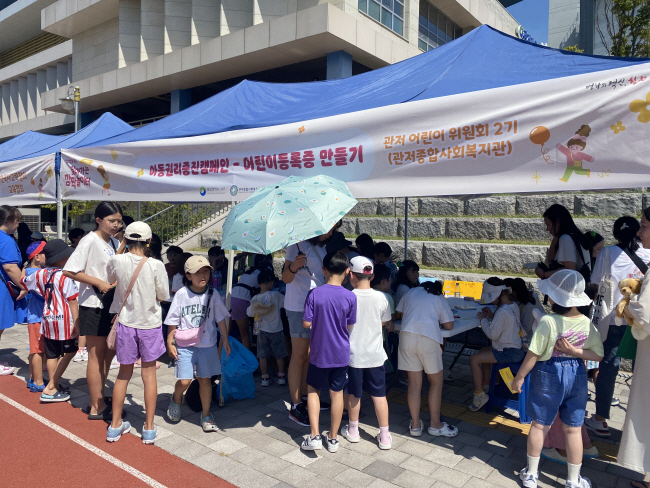 대전 서구 관저종합사회복지관의 관저 어린이 위원회에 참여한 아동들이 지난해 9월 9일 관저체육공원에서 열린 놀이축제 ‘2023 찾아가는 깜짝놀이터 키즈팡!’에서 어린이등록증 만들기 등 아동권리 증진 캠페인 부스를 운영하고 있다. 초록우산 제공