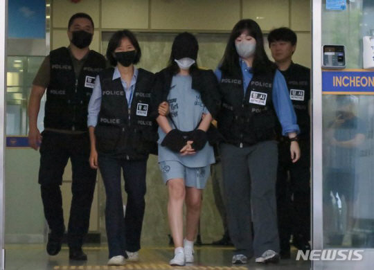 생후 1주일된 딸을 경기 김포시 한 텃밭에 암매장한 혐의를 받은 40대 친모가 지난해 7월 인천 미추홀구 미추홀경찰서에서 검찰로 송치되고 있다. 뉴시스