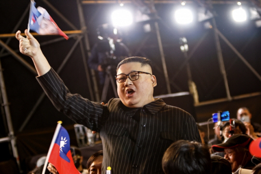 김정은 북한 국무위원장 분장을 한 중국계 호주 국적 코미디언 하워드X가 대만 선거 전날인 12일 밤 신베이에서 열린 국민당 유세에 참석해 깃발을 흔들고 있다. 이 EPA 연합뉴스
