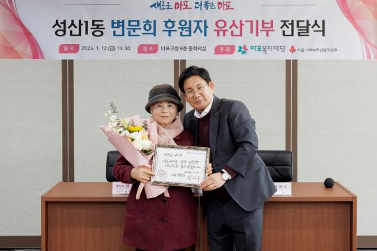 지난 12일 변문희 어르신의 효도밥상 등 후원 기탁식에서 변문희(왼쪽) 어르신이 박강수 마포구청장이 직접 쓴 손글씨를 들고 함께 사진을 찍고 있다. 마포구청 제공