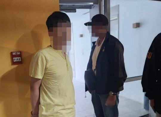 46억 원을 횡령해 해외로 도피한 국민건강보험공단 전직 직원(왼쪽)이 지난 9일 오후 필리핀 마닐라의 한 리조트에서 현지 경찰에 체포되는 모습. 경찰청 제공