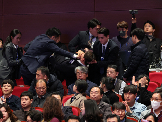 강성희 진보당 의원이 18일 전주시 덕진구 한국소리문화의전당 모악당에서 열린 전북특별자치도 출범식에서 윤석열 대통령이 입장하며 참석자들과 악수하는 동안 경호원들에게 제지당해 끌려나가고 있다. 진보당 측은 "강 의원이 윤 대통령과 악수하며 ‘국정기조를 바꾸지 않으면 국민들이 불행해집니다’라는 말을 건넨 순간 경호원들이 제지했다"고 주장했다. 연합뉴스