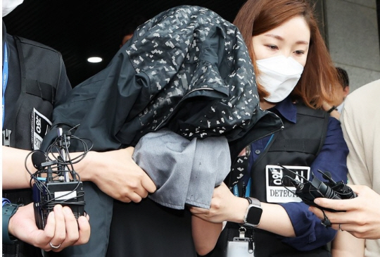 영아 2명을 살해하고 냉장고에 시신을 유기한 친모 A 씨가 지난해 6월30일 오전 경기 수원시 영통구 수원남부경찰서 유치장에서 나와 검찰로 송치되고 있다. 연합뉴스