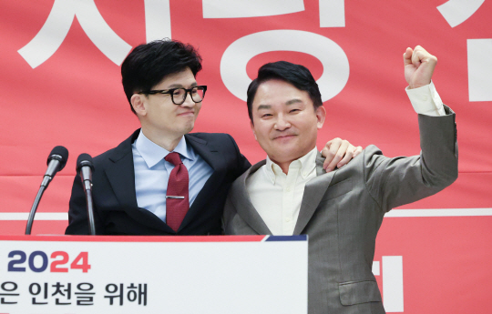 한동훈 국민의힘 비상대책위원장과 원희룡 전 국토교통부 장관이 지난 16일 인천 계양구 카리스 호텔에서 열린 인천시당 신년인사회에 참석해 손을 들고 있다. 연합뉴스