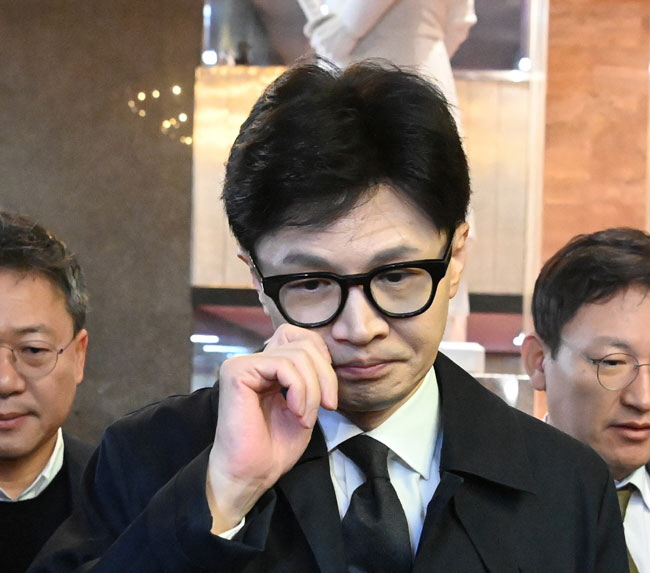 한동훈 국민의힘 비상대책위원장이 22일 오전 국회 출근길에서 기자들로부터 최근 용산 대통령실과의 갈등과 관련된 질의에 답한 뒤 안경을 고쳐 쓰면서 집무실로 향하고 있다.  곽성호 기자