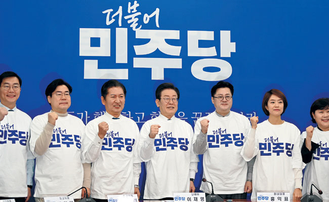 이재명(가운데) 더불어민주당 대표와 당지도부가 24일 오전 국회에서 열린 민주당 당 로고와 새 PI(상징·Party Identity) 선포식에 참석해 파이팅을 외치고 있다. 왼쪽부터 장경태·박찬대·정청래 최고위원, 이 대표, 홍익표 원내대표, 고민정·서영교 최고위원.  박윤슬 기자