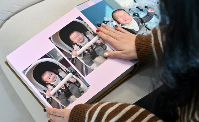 불의의 사고로 뇌사 추정 상태에 빠졌다가 생후 13개월 때 심장·폐·간 등 장기 기증을 하고 세상을 떠난 고 서정민 군의 어머니 이나라(32) 씨가 지난 16일 경기 하남시 자택에서 아들의 건강했던 생전 모습이 담긴 사진을 어루만지고 있다.    백동현 기자