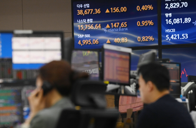 미국 스탠다드앤드푸어스(S&P)500 지수가 5000 돌파를 목전에 둔 8일 오전 서울 중구 을지로 하나은행 딜링룸에서 딜러들이 모니터를 주시하고 있다.  김동훈 기자