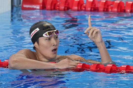 김우민이 12일 오전(한국시간) 카타르 도하 어스파이어돔에서 열린 2024 국제수영연맹 세계선수권대회 남자 자유형 400m 결승에서 1위로 골인한 후 1등을 의미하는 검지를 펼쳐 세리머리를 하고 있다. AP뉴시스