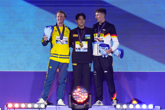 김우민(가운데)이 12일 오전(한국시간) 카타르 도하 어스파이어돔에서 열린 2024 국제수영연맹 세계선수권대회 남자 자유형 400m 결승에서 금메달을 차지한 뒤 시상대에서 금메달을 목에 걸고 다른 메달리스트과 기념 촬영을 하고 있다.  AP뉴시스
