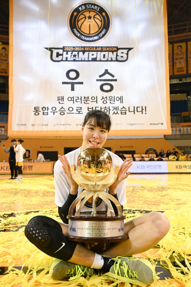 KB의 박지수가 14일 충북 청주체육관에서 열린 우리은행 우리WON 2023∼2024 여자프로농구에서 BNK를 꺾고 정규리그 1위를 확정한 뒤 트로피를 품고 포즈를 취하고 있다.  WKBL 제공