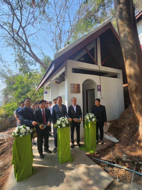 15일 경기 수원시와 세계화장실협회(WTA)가 라오스 루앙프라방 시 푸시산 캄용마을 일원에 건립한 공중 화장실 앞에서 수원시청·세계화장실협회·현지 관계자들이 준공 기념촬영을 하고 있다. 수원시청 제공