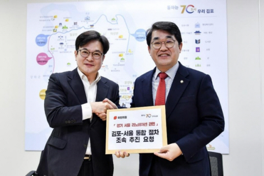 김병수(왼쪽) 김포시장이 15일 김포시청에서 배준영 국민의힘 경기-서울 리노베이션 태스크포스(TF) 위원장과 면담을 한 뒤 경기 김포시의 서울 편입 문제와 관련한 건의문을 전달하고 있다. 연합뉴스