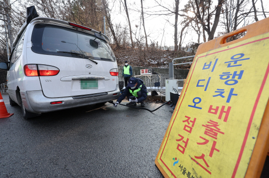 수도권에서 고농도 미세먼지 비상저감조치가 시행된 지난해 말 서울 양천구 서부트럭터미널 인근에서 서울시 관계자가 운행차 배출가스 단속을 하는 모습.연합뉴스