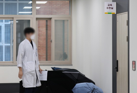 19일 오전 광주 동구 전남대학교병원 교육수련실 앞에서 한 전공의가 퇴직자용 정보보호 및 비밀유지 서약서와 사직서를 제출하러 가고 있다. 연합뉴스