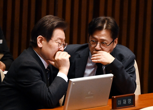 이재명(왼쪽) 더불어민주당 대표와 홍익표 원내대표가 21일 오전 국회 본회의장에서 대화를 나누고 있다.   박윤슬 기자